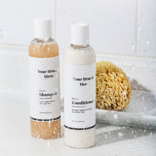 Two bottles of shampoo and conditioner with a sponge on a white background